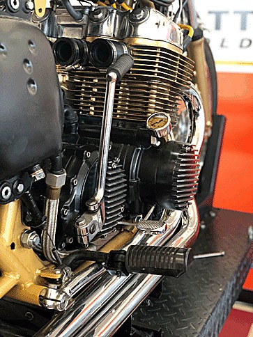 Gold-finned inline-four café racer engine close-up